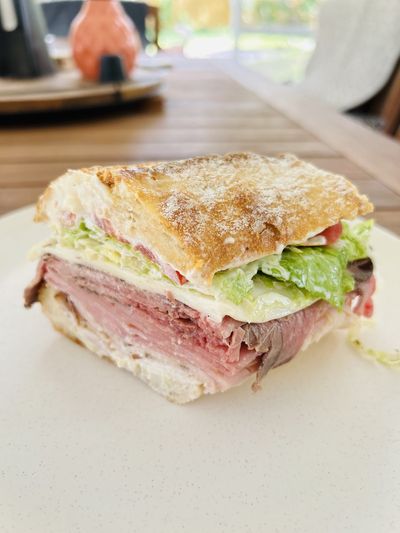 A roast beef sub stacked with cheese, lettuce and tomato on a crusty roll at Manzano's Deli